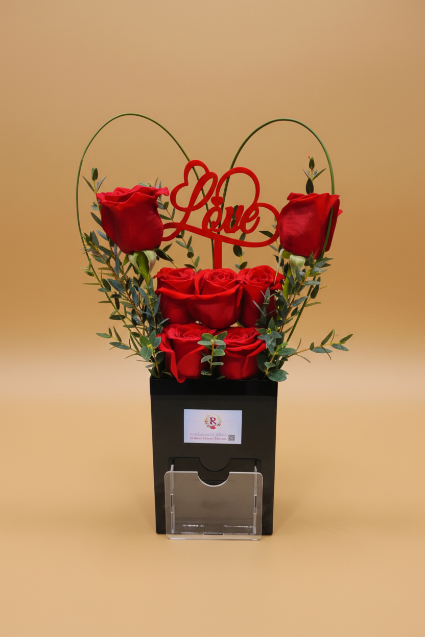Bouquet of red roses with 'Love' decoration in a black box on a white background