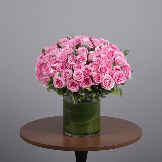 Bouquet of pink roses in a clear vase on a white background