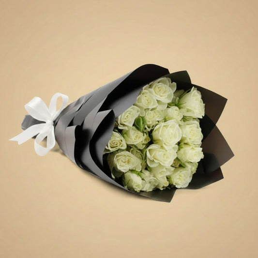 Bouquet of white roses wrapped in black paper with a brown ribbon on a white background