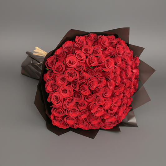 Bouquet of red roses wrapped in brown paper on a white background