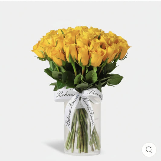 Bouquet of yellow roses in a clear vase with a white ribbon on a light gray background