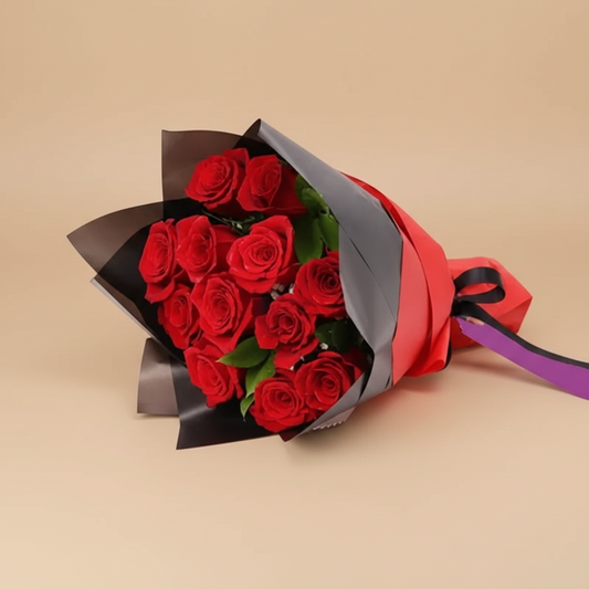 Bouquet of red roses wrapped in brown paper with a red ribbon on a white background.