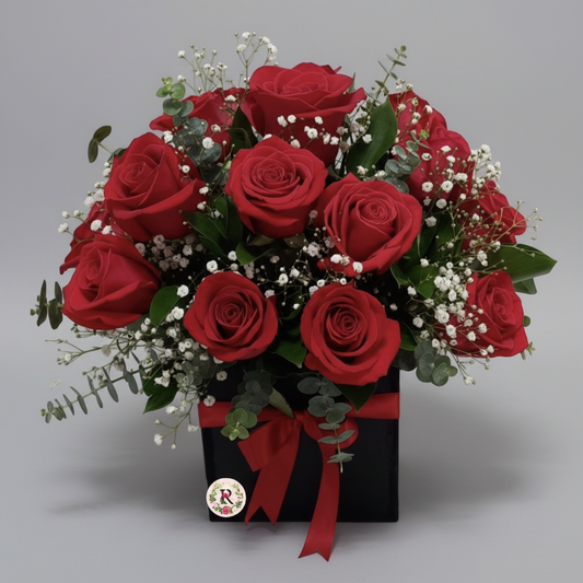Bouquet of red roses with greenery and a red ribbon on a white background