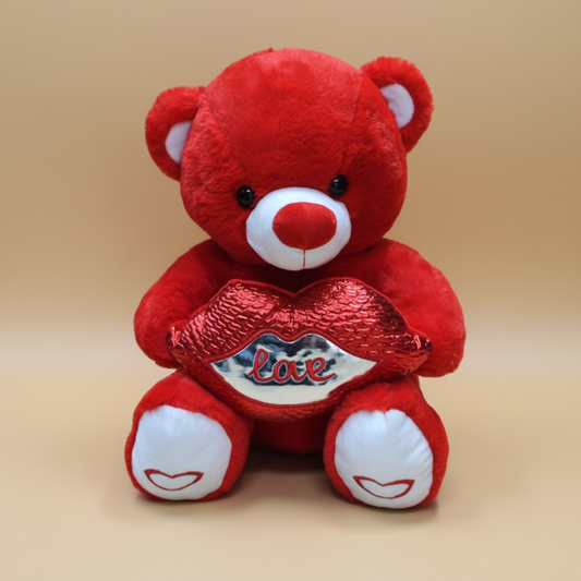Red teddy bear with a 'love' heart and bow tie on a white background